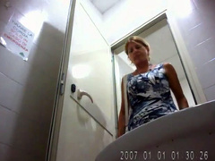 Blonde milf in a blue dress uses public toilet
