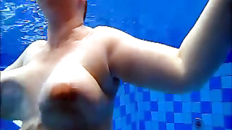 Curvy naked body floats in the pool