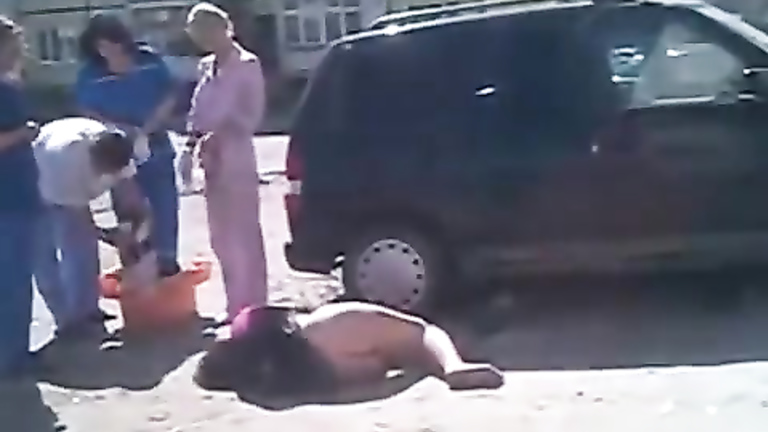 Drunken girl lies on the road with her ass naked