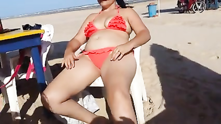 Chubby woman sets up her red bikini at the beach