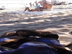 Seductive nudist girlfriend has her pussy exposed on the middle of the beach