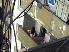 Girl sits on his balls out on the balcony