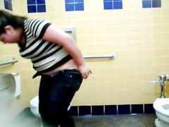 Chubby woman takes a leak in a public WC